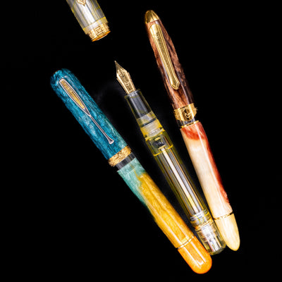 An overhead view of 3 different Nahvalur foutain pens with 2 being capped and 1 uncapped showcasing its gold plated nib.