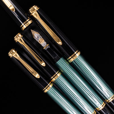 An overhead view of 4 different M series Pelikans with 3 capped, 1 uncapped showcasing the beautiful nib.