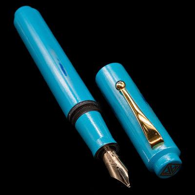 A full view of the AP Limited Editions Proplyd Aqua Fountain Pen uncapped, with its cap laying next to the pen. 