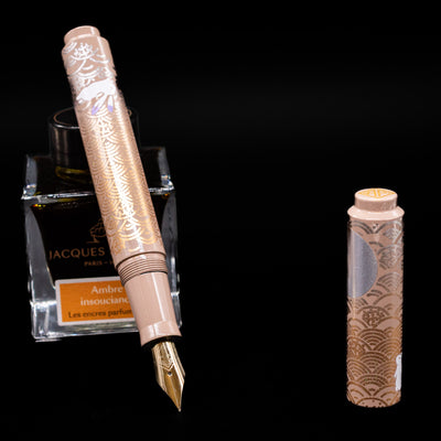 AP Limited Editions Sakura Lacquer Art Fountain Pen - Rabbits in a Summer Garden leaning on an ink bottle uncapped showcasing the detailing on the nib.