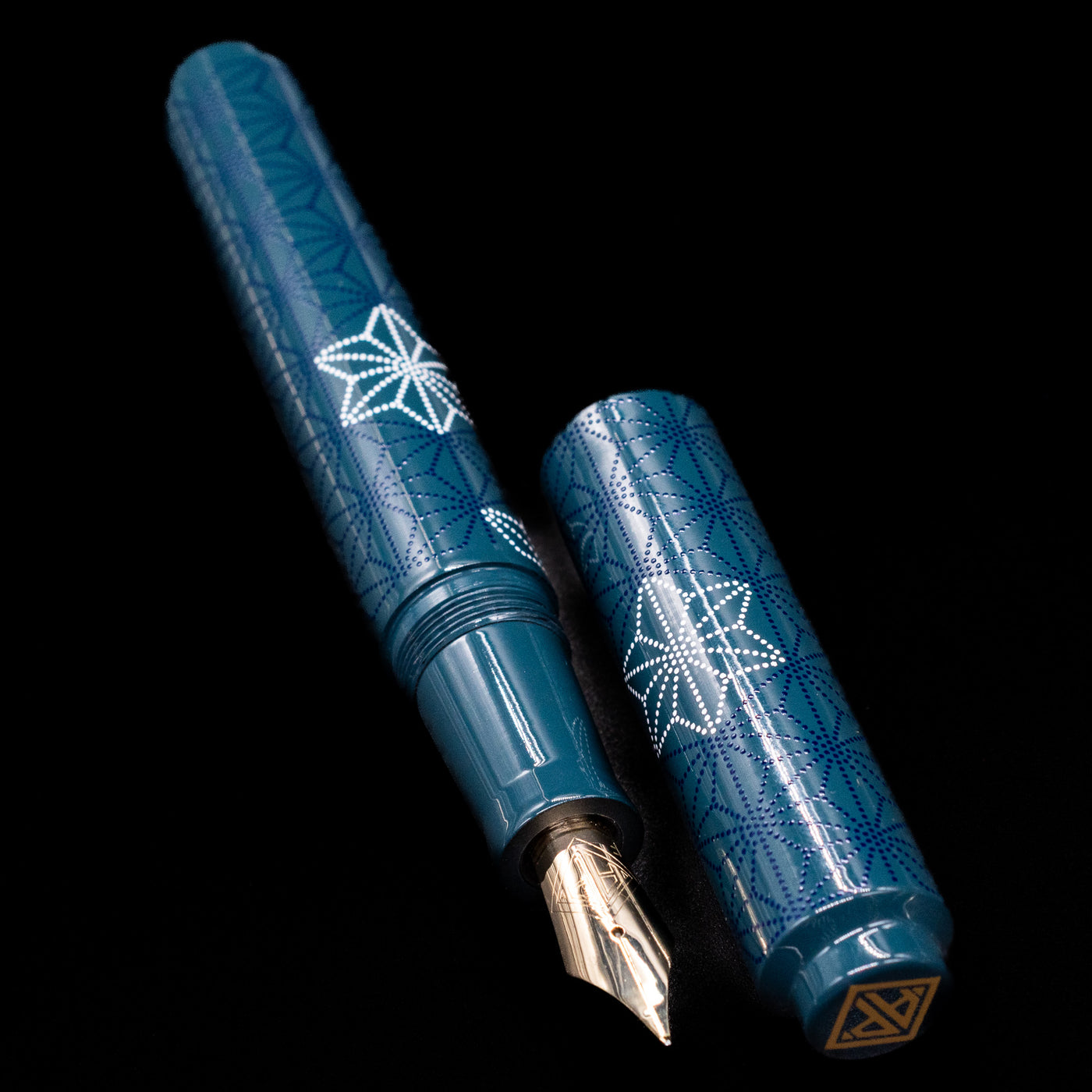  A full view of the AP Limited Editions Sakura Lacquer Art Fountain Pen - Snowflakes Blue uncapped, with its cap laying next to the pen.