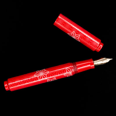 An overhead view of the AP Limited Editions Sakura Lacquer Art Fountain Pen - Snowflakes Red uncapped.