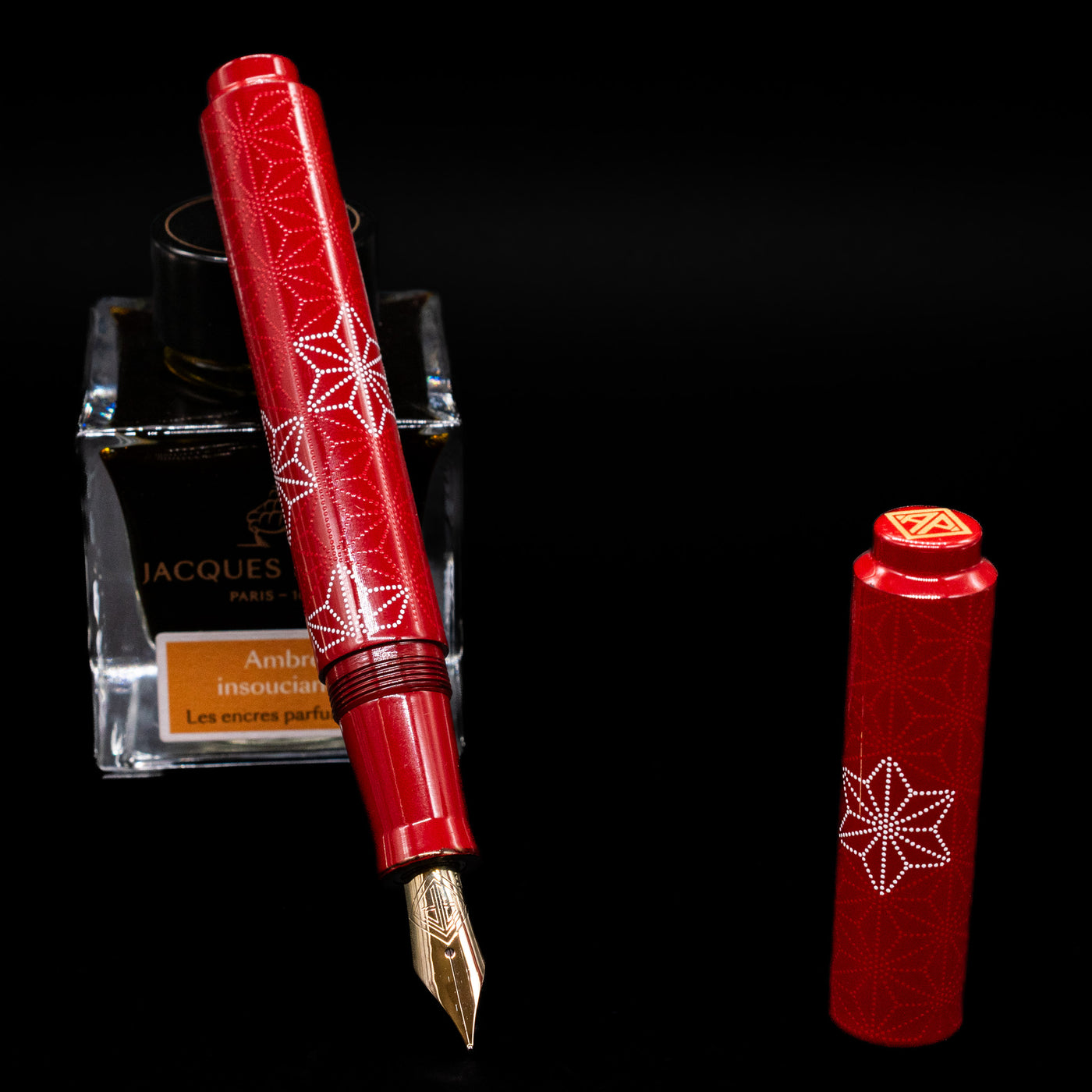 AP Limited Editions Sakura Lacquer Art Fountain Pen - Snowflakes Red  leaning on an ink bottle uncapped showcasing the detailing on the nib.