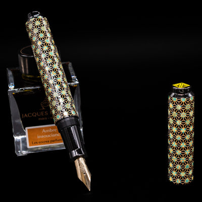 AP Limited Editions Sakura Lacquer Art Fountain Pen - Teal Stars leaning on an ink bottle uncapped showcasing the detailing on the nib.