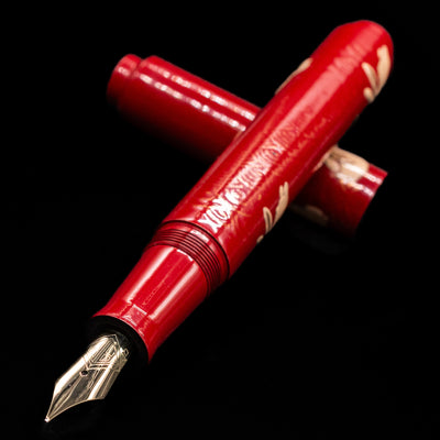 AP Limited Editions Sakura Lacquer Art Fountain Pen - Year of the Rabbit laying across its own cap, crossed, with a focus on the nib.
