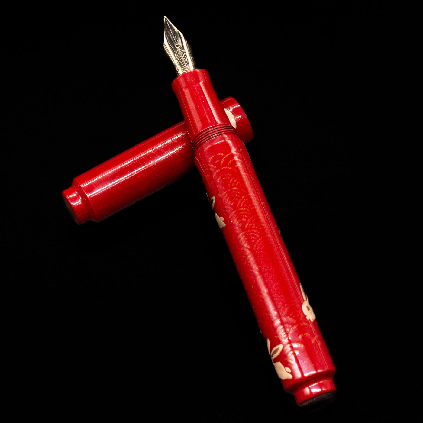AP Limited Editions Sakura Lacquer Art Fountain Pen - Year of the Rabbit laying on top of its cap in a crossed position showing full view of the entire uncapped pen.