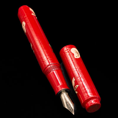  A full view of the AP Limited Editions Sakura Lacquer Art Fountain Pen - Year of the Rabbit uncapped, with its cap laying next to the pen. 