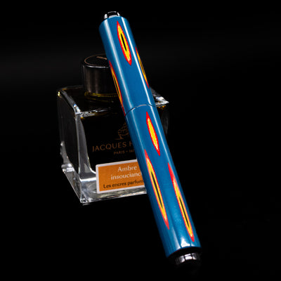 AP Limited Editions Urushi Lacquer Art Fountain Pen - Amorphous Splendour capped, leaning against an ink bottle. 