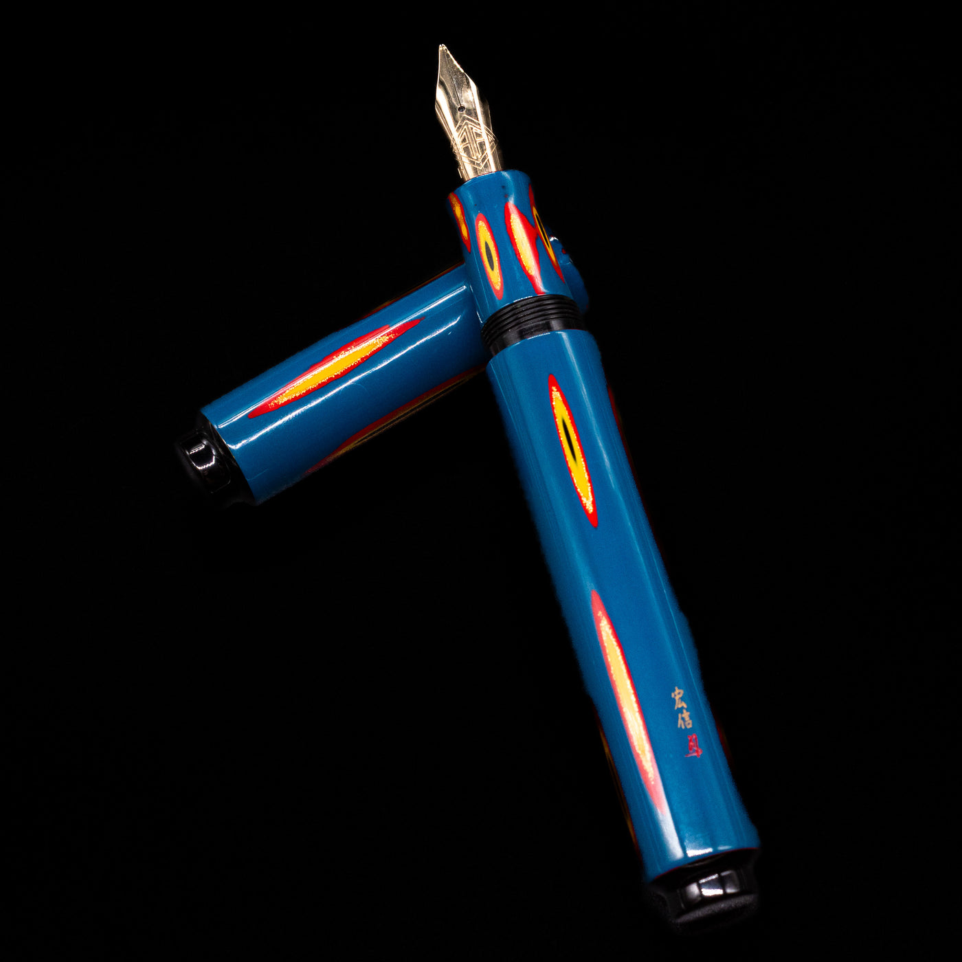 AP Limited Editions Urushi Lacquer Art Fountain Pen - Amorphous Splendour  laying on top of its cap in a crossed position showing full view of the entire uncapped pen.