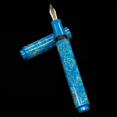 AP Limited Editions Urushi Lacquer Art Fountain Pen - Blue Bliss laying on top of its cap in a crossed position showing full view of the entire uncapped pen.