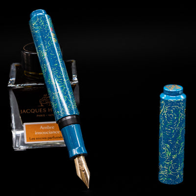 AP Limited Editions Urushi Lacquer Art Fountain Pen - Blue Bliss leaning on an ink bottle uncapped showcasing the detailing on the nib.