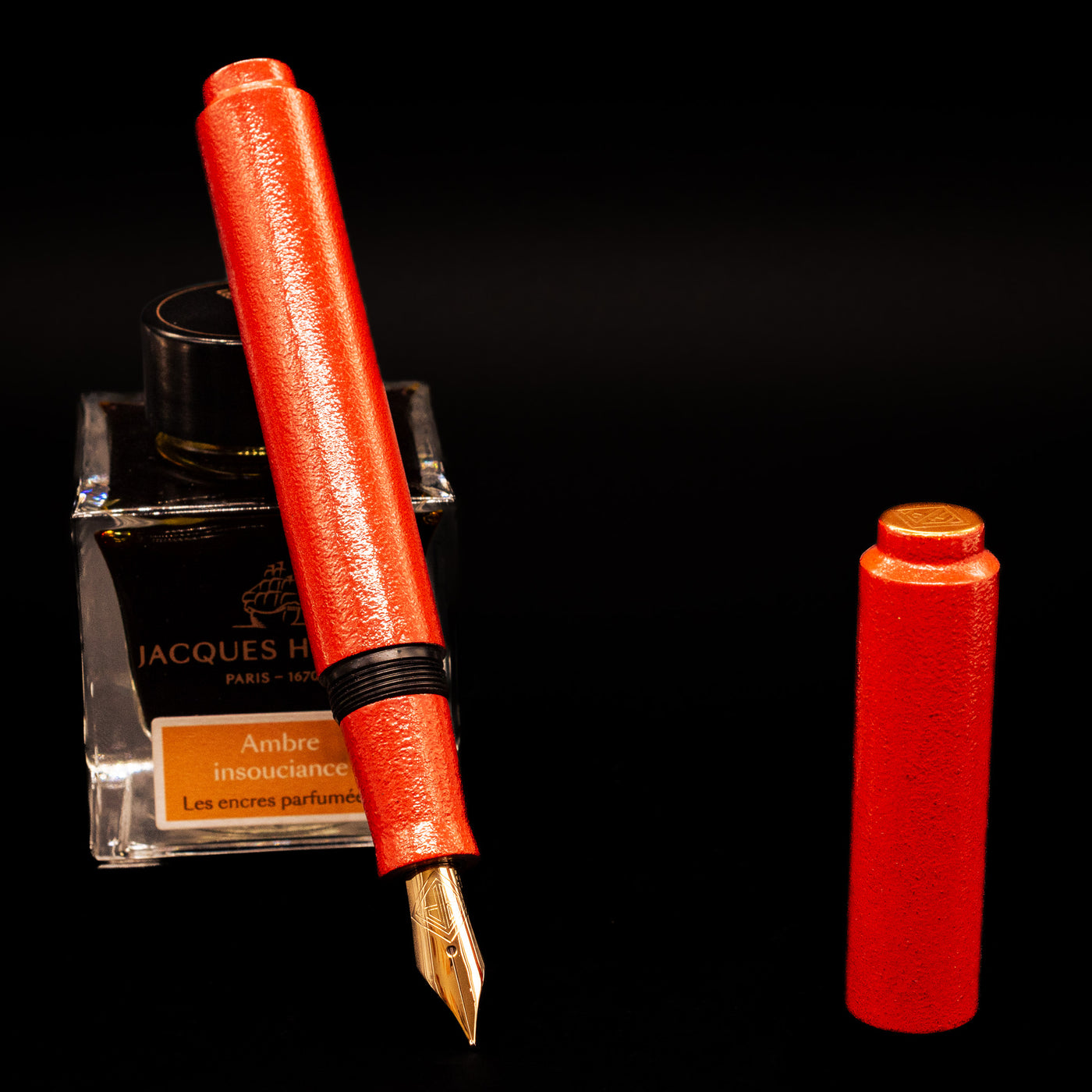 AP Limited Editions Urushi Lacquer Art Fountain Pen - Colors of the Cosmos Aldebaran leaning on an ink bottle uncapped showcasing the detailing on the nib.