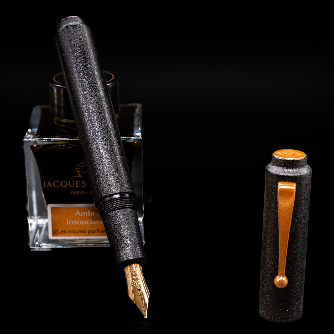 AP Limited Editions Urushi Lacquer Art Fountain Pen - Ishiji Black & Gold leaning on an ink bottle uncapped showcasing the detailing on the nib.