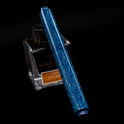 AP Limited Editions Urushi Lacquer Art Fountain Pen - Midnight capped, leaning against an ink bottle. 