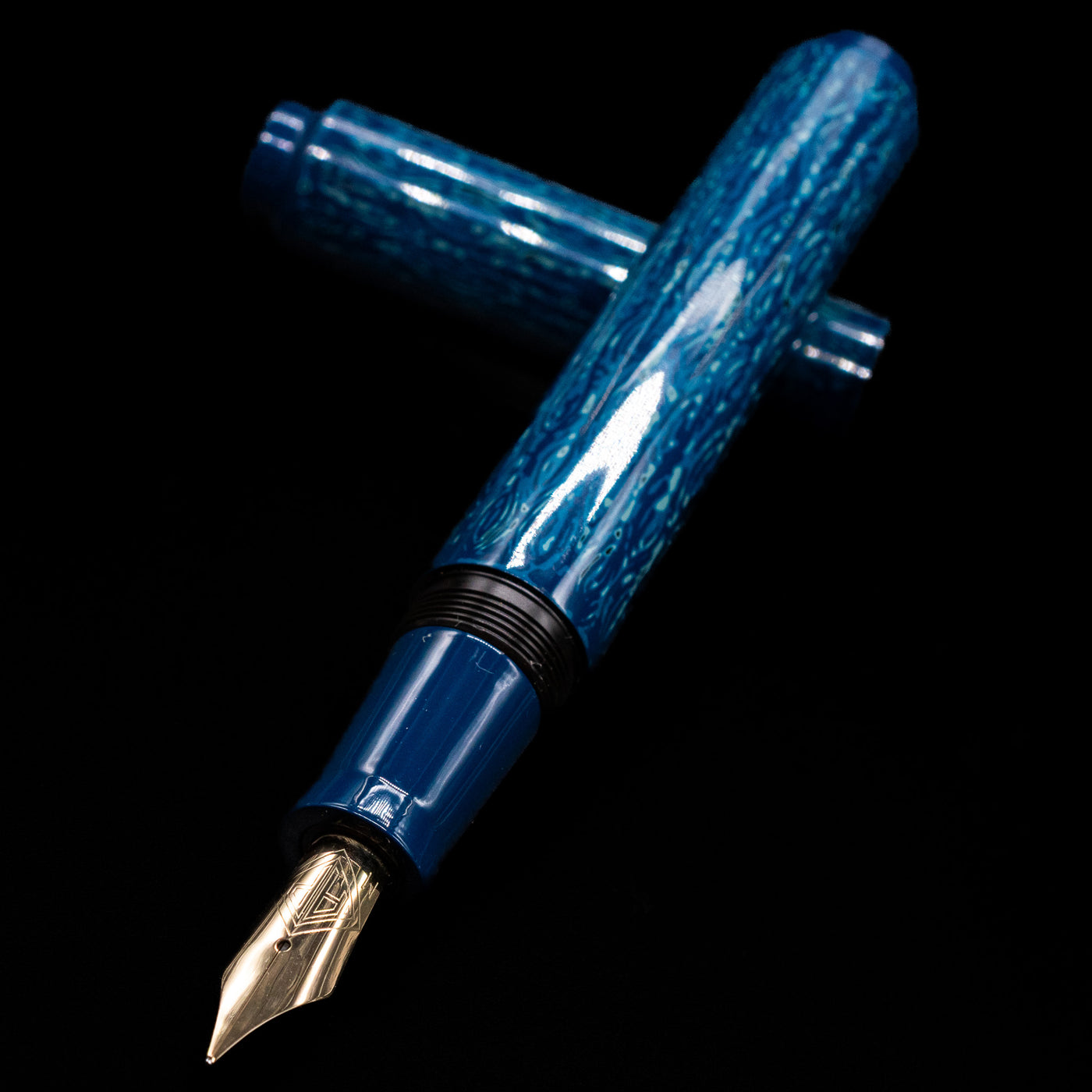 AP Limited Editions Urushi Lacquer Art Fountain Pen - Midnight laying across its own cap, crossed, with a focus on the nib.
