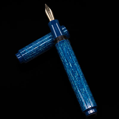 AP Limited Editions Urushi Lacquer Art Fountain Pen - Midnight laying on top of its cap in a crossed position showing full view of the entire uncapped pen.