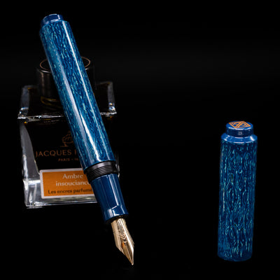 AP Limited Editions Urushi Lacquer Art Fountain Pen - Midnight leaning on an ink bottle uncapped showcasing the detailing on the nib.