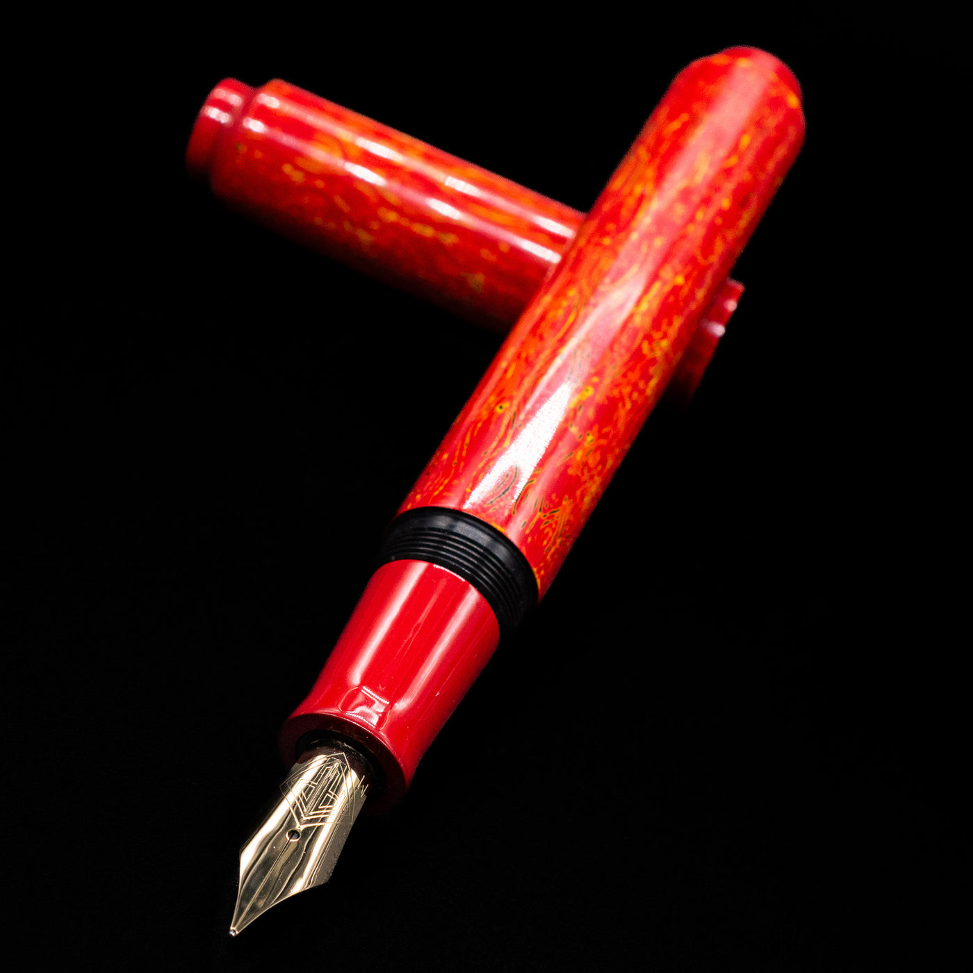 AP Limited Editions Urushi Lacquer Art Fountain Pen - Red Earth laying across its own cap, crossed, with a focus on the nib.