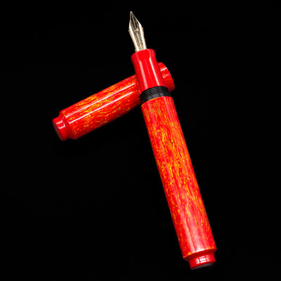 AP Limited Editions Urushi Lacquer Art Fountain Pen - Red Earth laying on top of its cap in a crossed position showing full view of the entire uncapped pen.