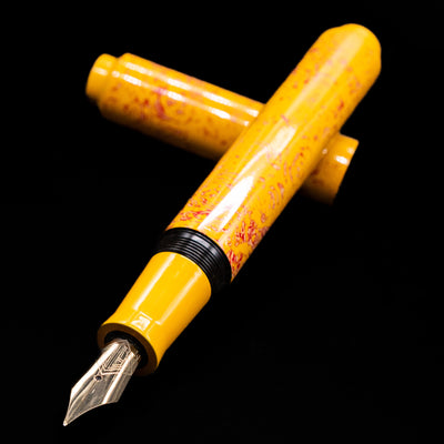 AP Limited Editions Urushi Lacquer Art Fountain Pen - Sunshine laying across its own cap, crossed, with a focus on the nib.
