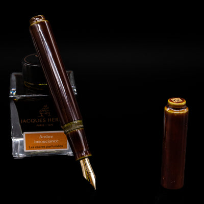 AP Limited Editions Urushi Lacquer Art Fountain Pen - Tamenuri Green leaning on an ink bottle uncapped showcasing the detailing on the nib.