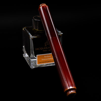 AP Limited Editions Urushi Lacquer Art Fountain Pen - Tamenuri Yellow capped, leaning against an ink bottle. 