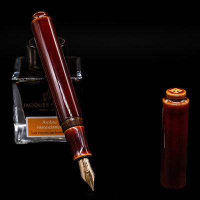 A full view of the AP Limited Editions Urushi Lacquer Art Fountain Pen - Tamenuri Yellow uncapped, with its cap laying next to the pen. 