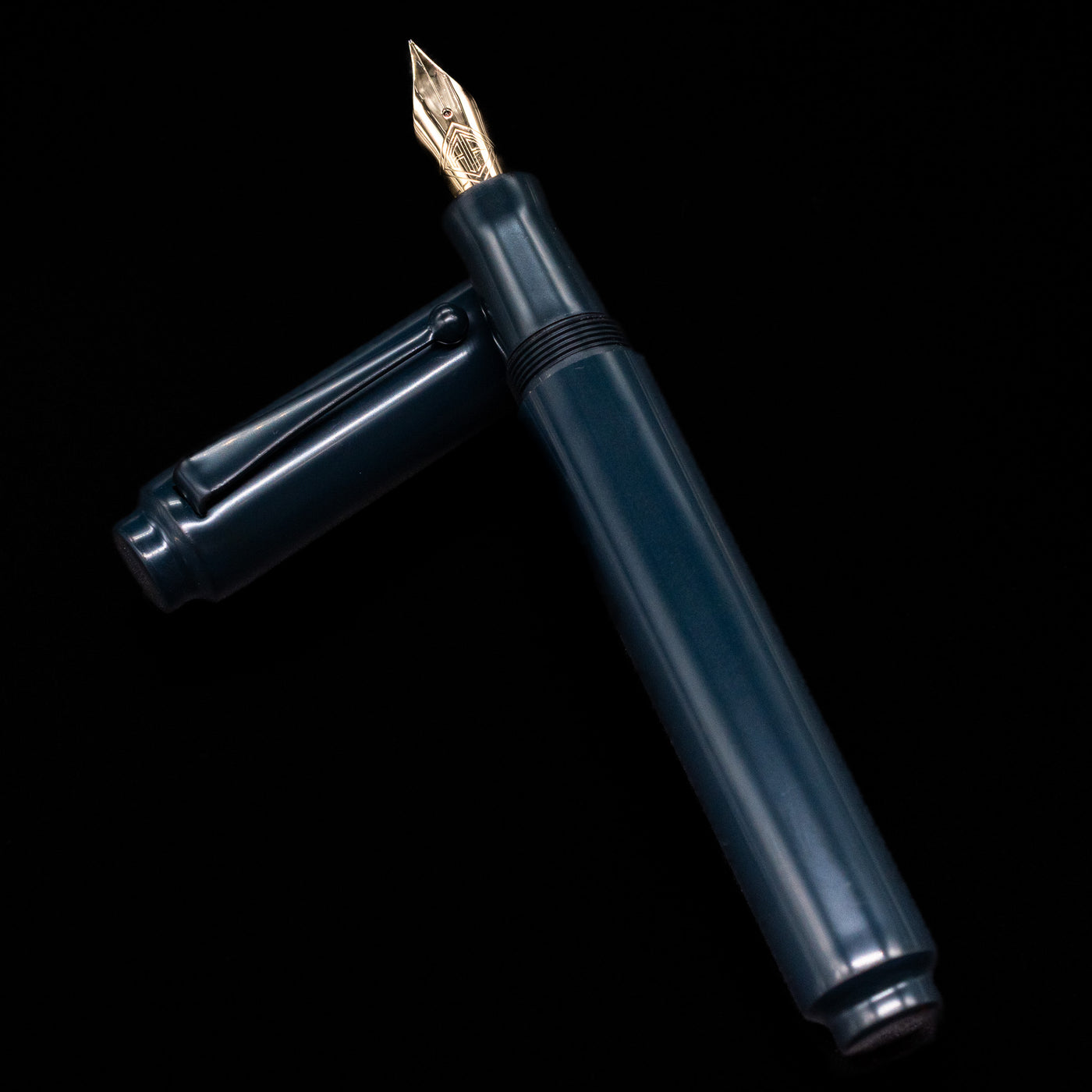 AP Limited Editions Urushi Lacquer Art Fountain Pen - Tetsu-Kon laying on top of its cap in a crossed position showing full view of the entire uncapped pen.