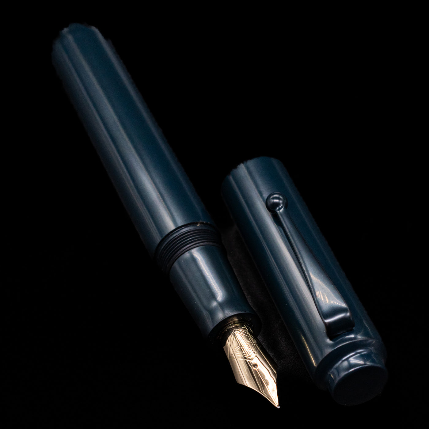 A full view of the AP Limited Editions Urushi Lacquer Art Fountain Pen - Tetsu-Kon uncapped, with its cap laying next to the pen. 