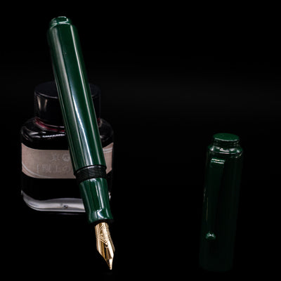 AP Limited Editions Urushi Lacquer Art Fountain Pen - Tokiwa Midori leaning on an ink bottle uncapped showcasing the detailing on the nib.