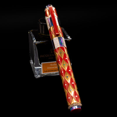 AP Limited Editions Writer Maki-e Fountain Pen - Aogai Deco capped, leaning against an ink bottle. 