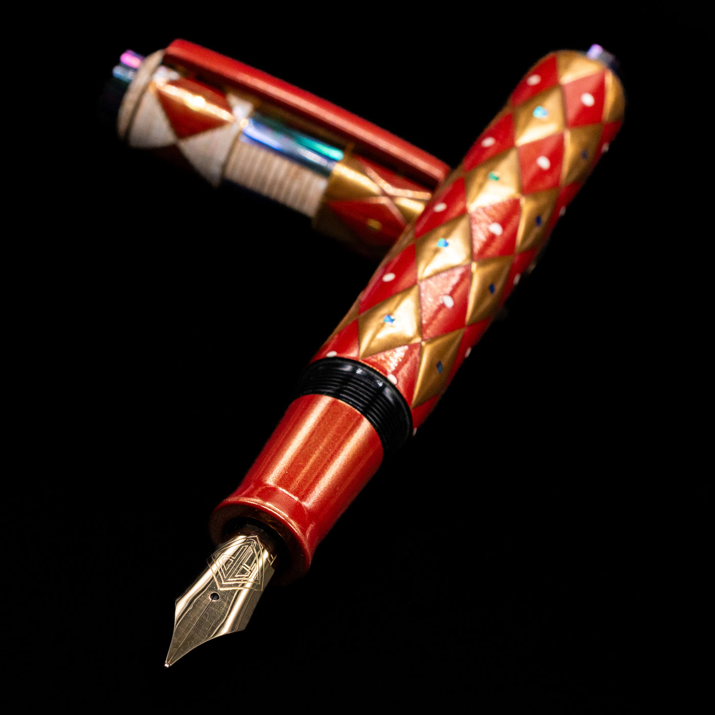 AP Limited Editions Writer Maki-e Fountain Pen - Aogai Deco laying across its own cap, crossed, with a focus on the nib.