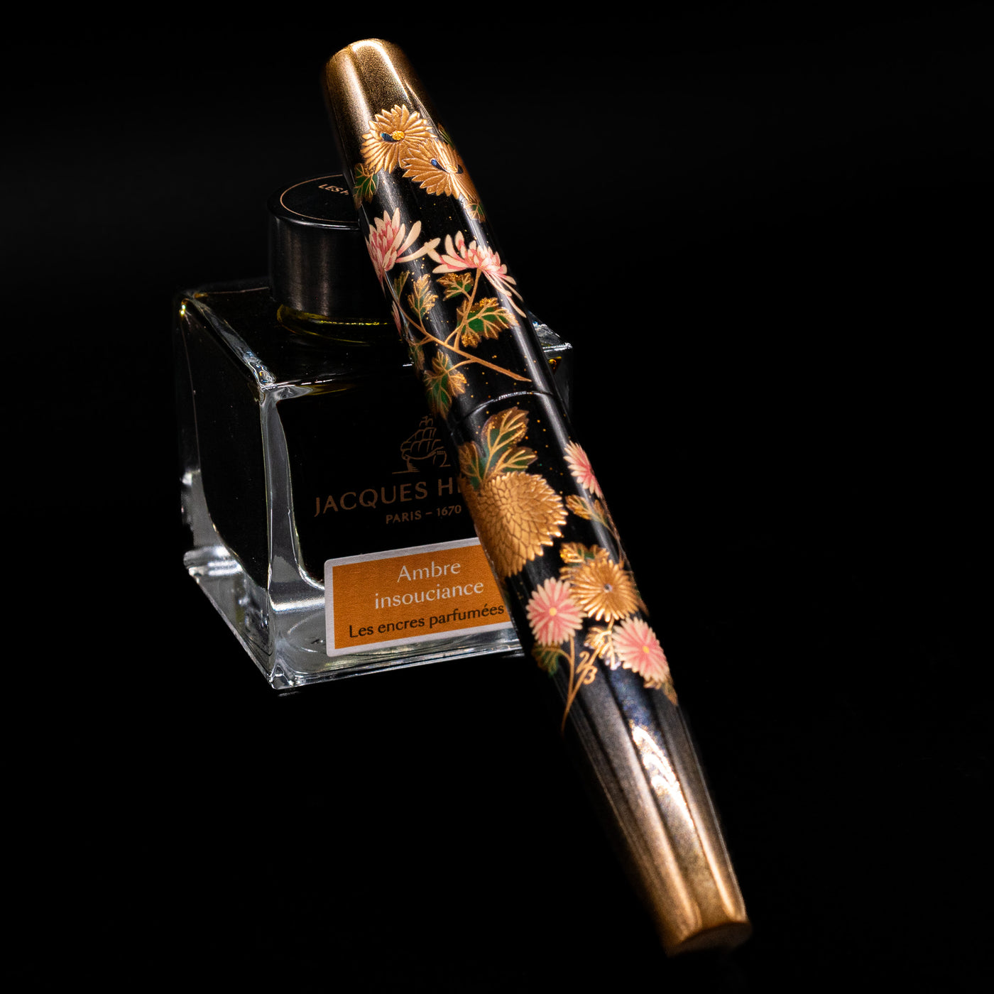 AP Limited Editions Writer Maki-e Fountain Pen - Chrystanthemum (Prototype) capped, leaning against an ink bottle. 