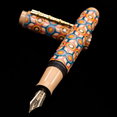 AP Limited Editions Writer Maki-e Fountain Pen - Orbit laying across its own cap, crossed, with a focus on the nib.