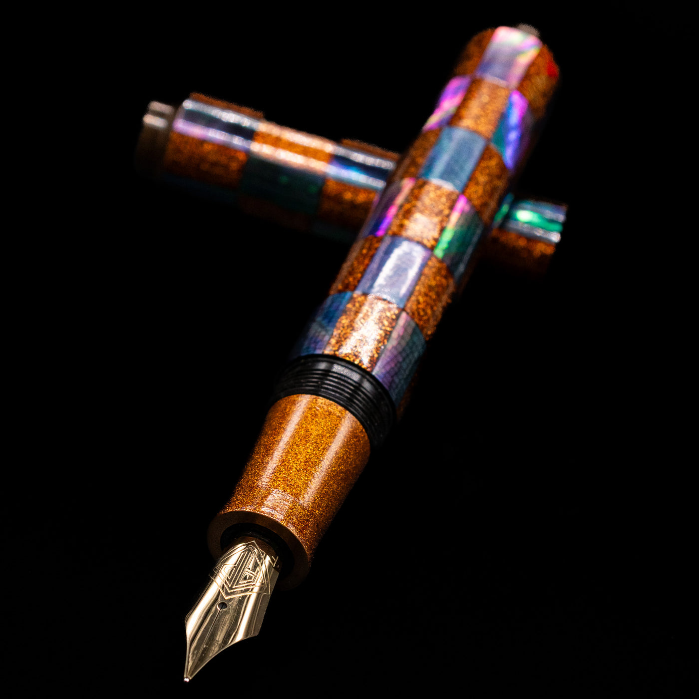 AP Limited Editions Writer Maki-e Fountain Pen - Sparkle laying across its own cap, crossed, with a focus on the nib.