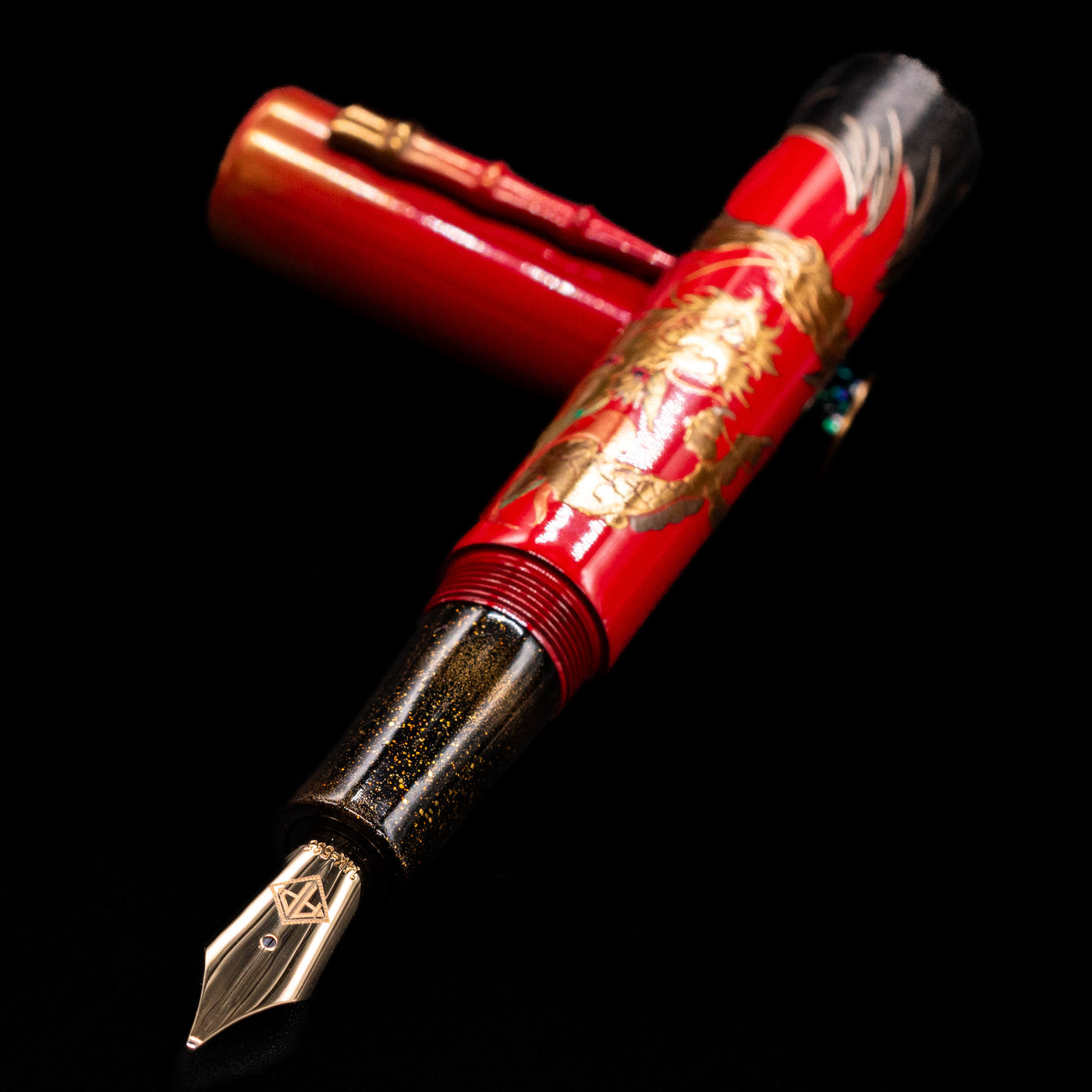 AP Limited Editions Writer Maki-e Fountain Pen - The Celebrated Dragon laying across its own cap, crossed, with a focus on the nib.