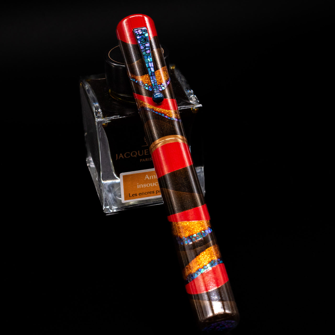 AP Limited Editions Writer Maki-e Fountain Pen - The Dunes capped, leaning against an ink bottle. 