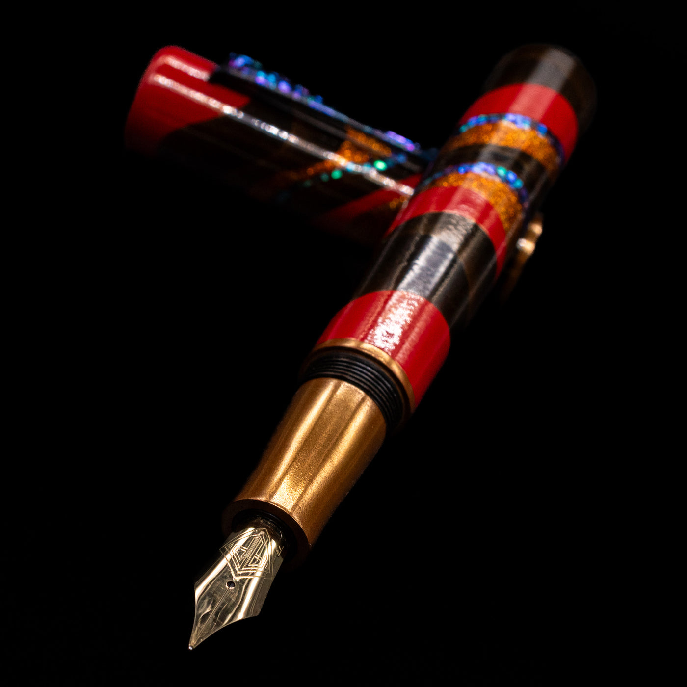 AP Limited Editions Writer Maki-e Fountain Pen - The Dunes laying across its own cap, crossed, with a focus on the nib.