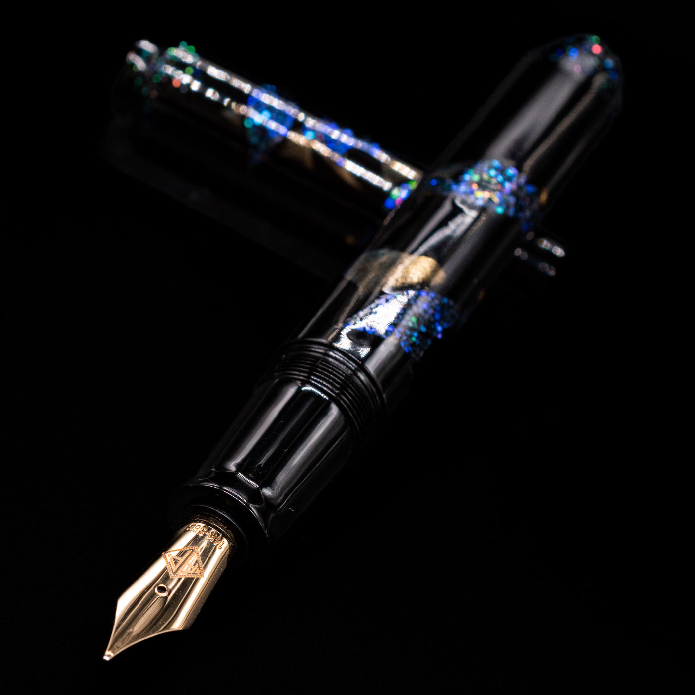 AP Limited Editions Writer Maki-e Fountain Pen - The Firefly Squid laying across its own cap, crossed, with a focus on the nib.
