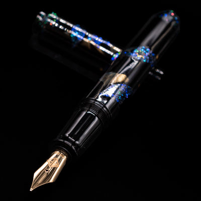 AP Limited Editions Writer Maki-e Fountain Pen - The Firefly Squid laying across its own cap, crossed, with a focus on the nib.