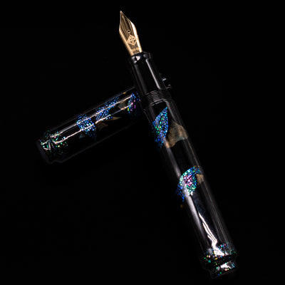 AP Limited Editions Writer Maki-e Fountain Pen - The Firefly Squid laying on top of its cap in a crossed position showing full view of the entire uncapped pen.