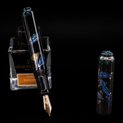 AP Limited Editions Writer Maki-e Fountain Pen - The Firefly Squid leaning on an ink bottle uncapped showcasing the detailing on the nib.