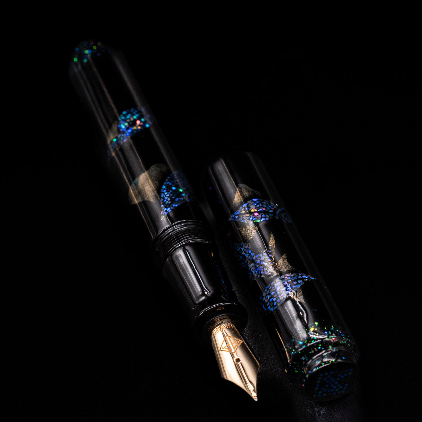  A full view of the AP Limited Editions Writer Maki-e Fountain Pen - The Firefly Squid uncapped, with its cap laying next to the pen. 