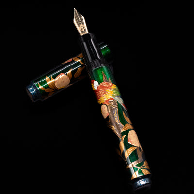 AP Limited Editions Writer Maki-e Fountain Pen - The Parrot with Peaches laying on top of its cap in a crossed position showing full view of the entire uncapped pen.
