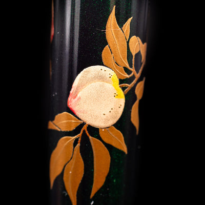 A close-up shot of a peach on the body of the AP Limited Editions Writer Maki-e Fountain Pen - The Parrot with Peaches.