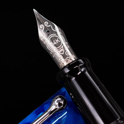 Close-up of the rhodium-plated 14k gold nib on the Aurora Optima Auroloide Blue & Chrome fountain pen, showing fine engravings and the Aurora logo.