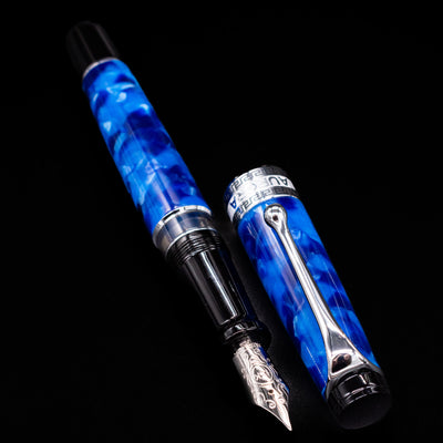 Aurora Optima Auroloide Blue & Chrome fountain pen displayed uncapped, revealing the marbled blue resin barrel, rhodium-plated grip section, and engraved nib.