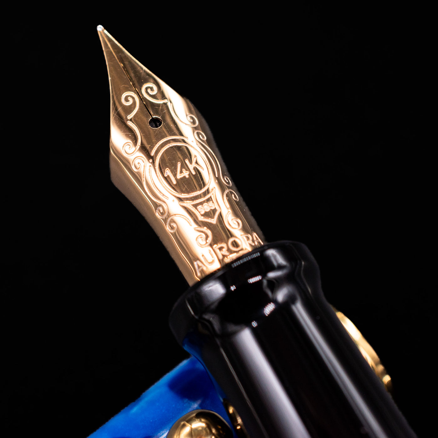 Close-up of the gold 14k nib on the Aurora Optima Auroloide Blue & Gold fountain pen, showing fine engravings and the Aurora logo.
