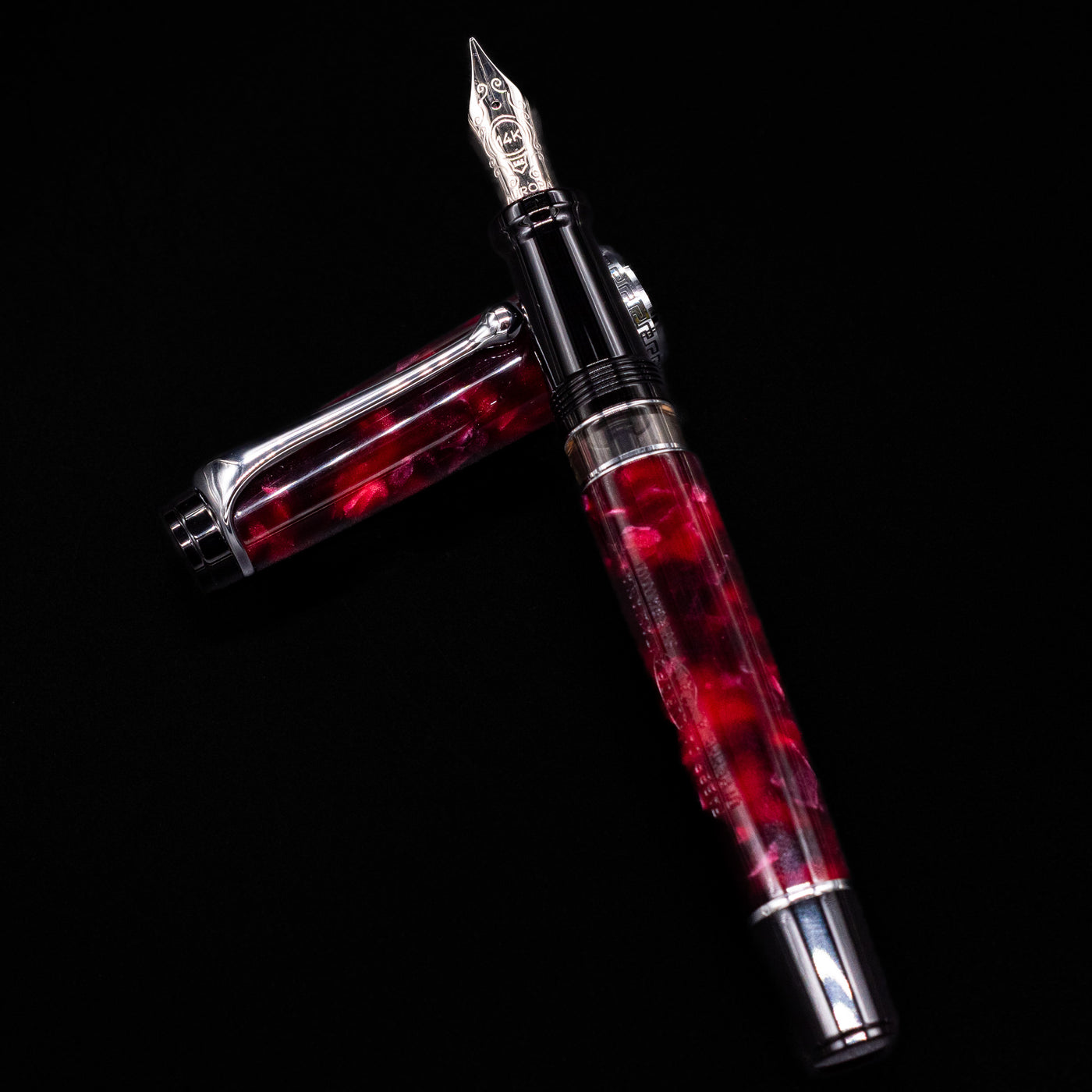 Aurora Optima Auroloide Burgundy fountain pen and cap arranged in a crossed position, showcasing the elegant marbled burgundy finish, engraved cap band, and silver clip.