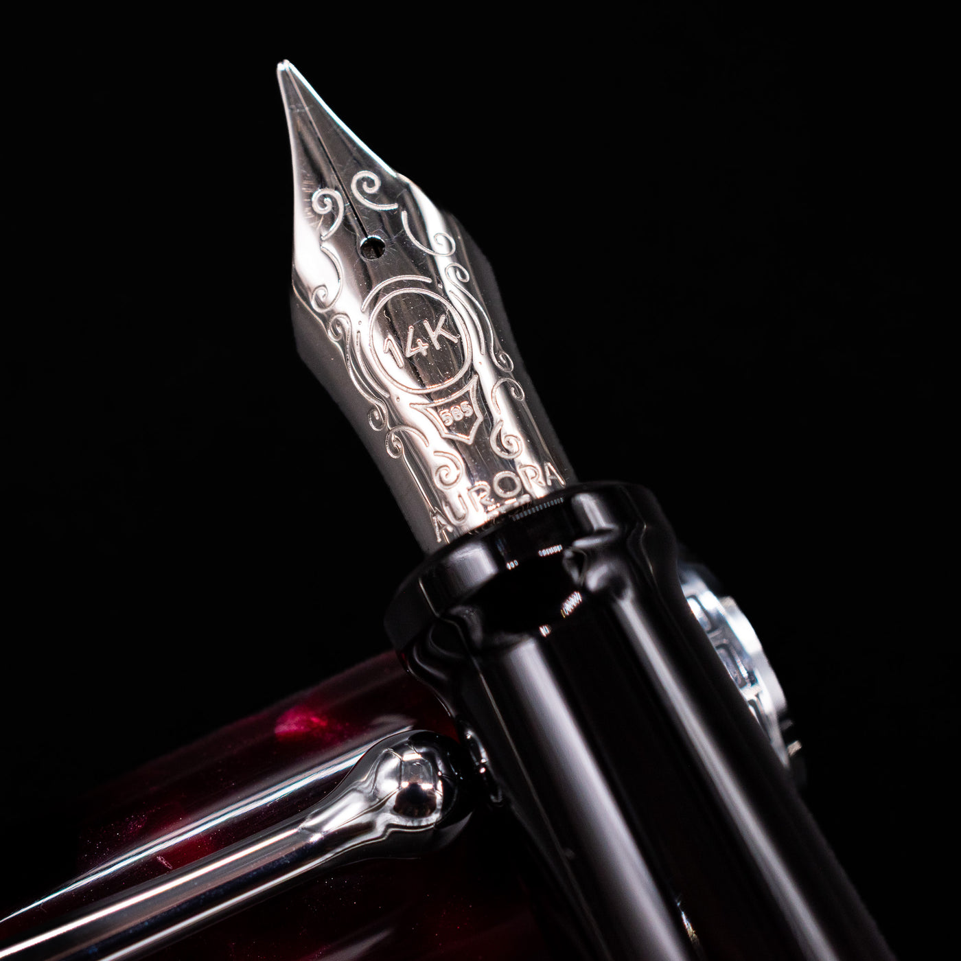 Close-up of the gold-plated 14k nib on the Aurora Optima Auroloide Burgundy fountain pen, showing fine engravings and the Aurora logo.